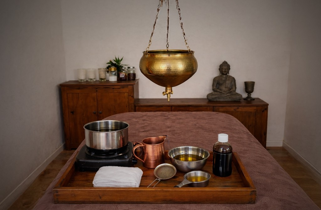 Ayurvedic treatment room with Shirodhara and oil massage setup for calming the nervous system